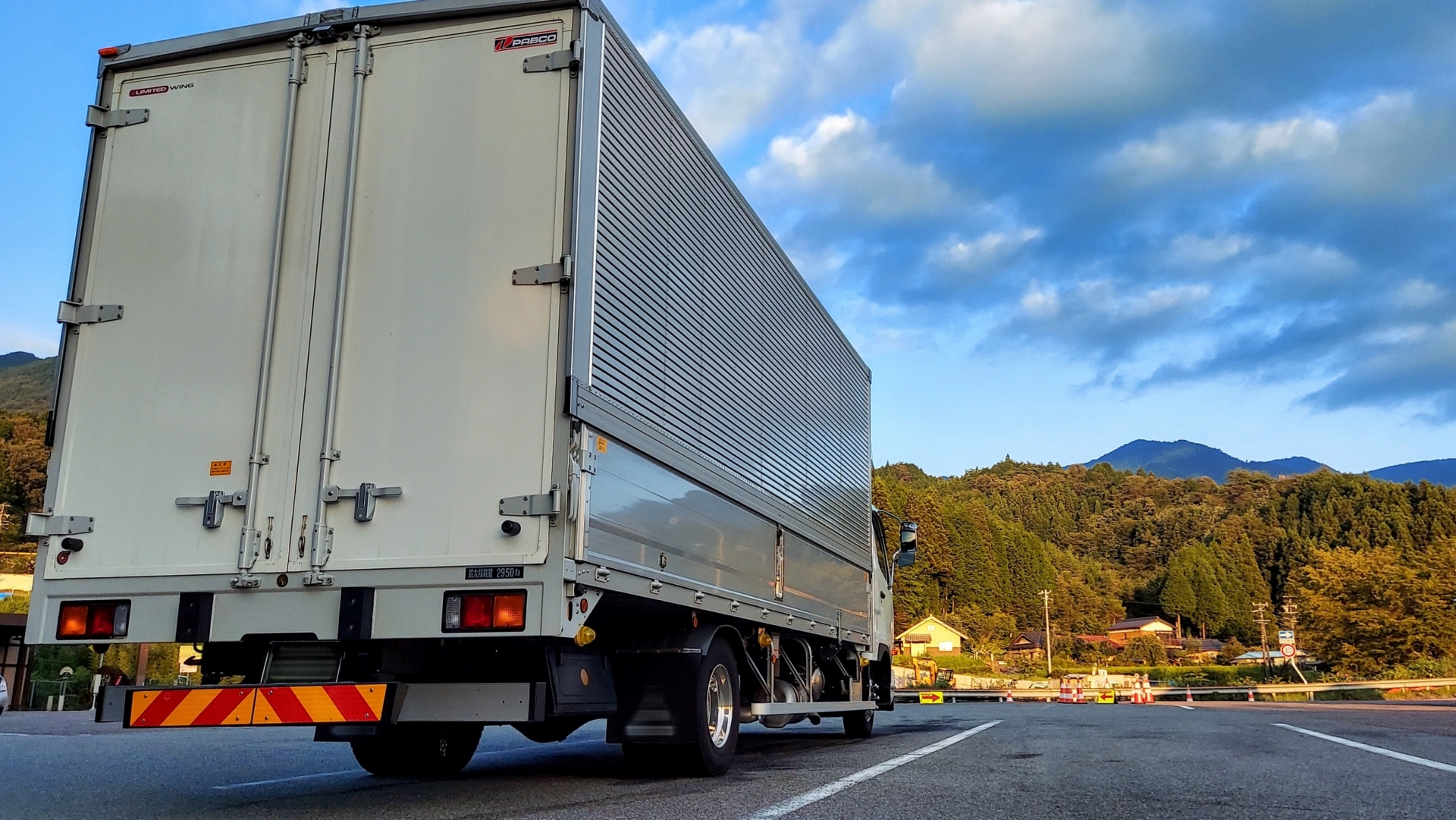 秋の道を運転するトラック